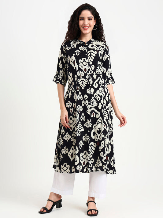 Woman wearing a black and white patterned kurta with white pants on a white background