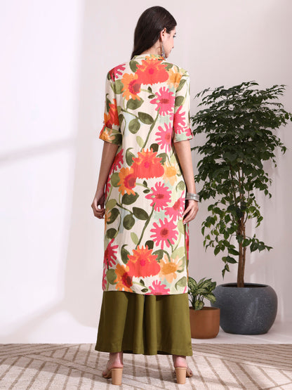Woman wearing a floral dress standing in a room with plants.